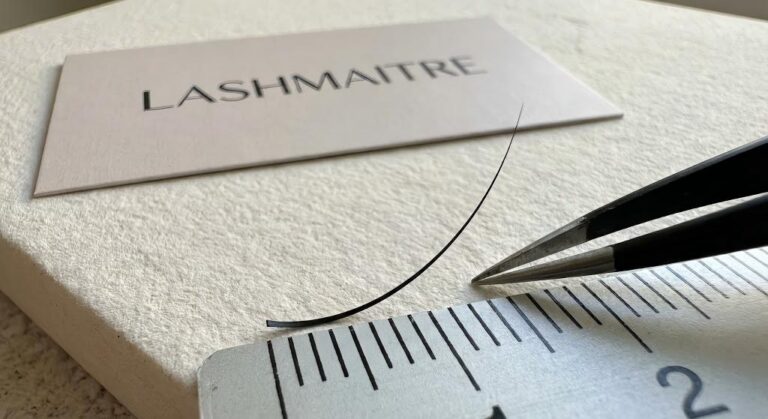 Macro photography of LASHMAITRE premium PBT fibers illustrating the ultra-lightweight composition of 0.03mm mega volume lashes designed for safe, long-length application.