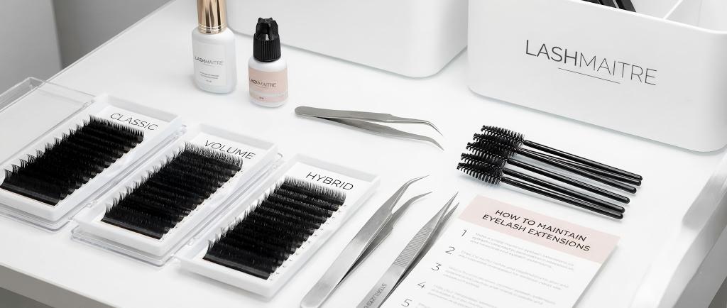 Professional salon workstation featuring LASHMAITRE tools and a guide on how to maintain eyelash extensions in a high-traffic environment.