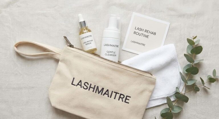 A flat lay photograph of the LASHMAITRE Lash Rehab Kit, including a repair serum, gentle cleanser, and a routine card, designed as a solution for clients who feel their eyelash extensions pulling my eyelashes out.