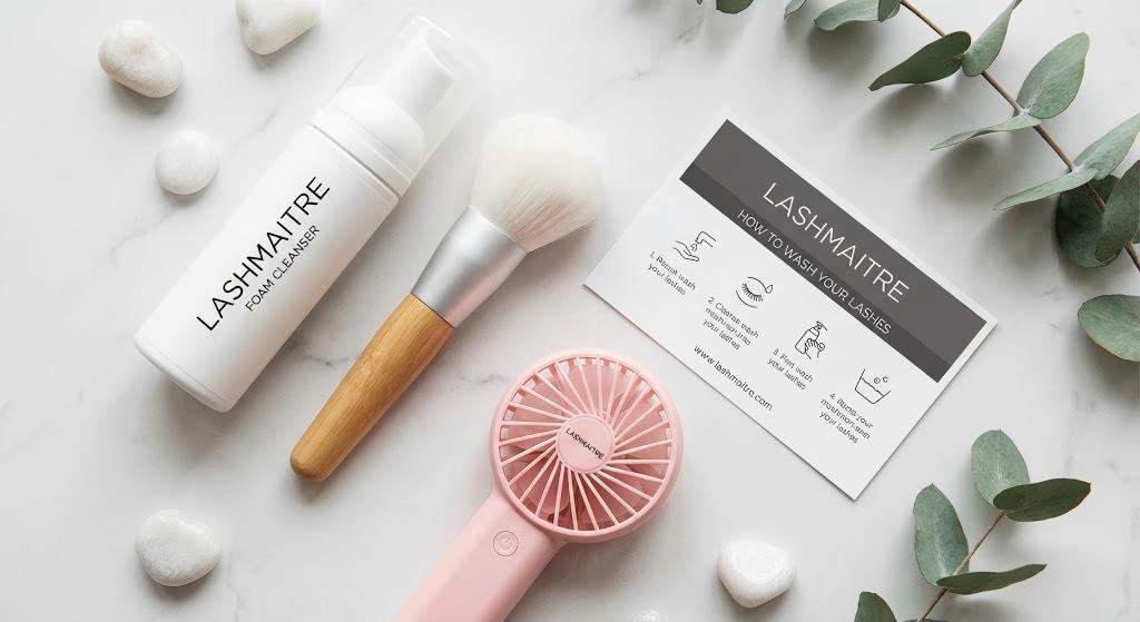 "LASHMAITRE professional aftercare kit flat lay featuring cleanser, brush, and drying fan, providing the essential tools for clients asking 'can i get my eyelash extensions wet'."