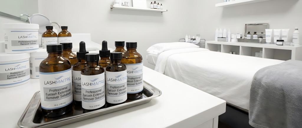 LASHMAITRE professional product display featuring a range of wholesale eyelash extension remover solutions in clinical packaging for U.S. salon suppliers.