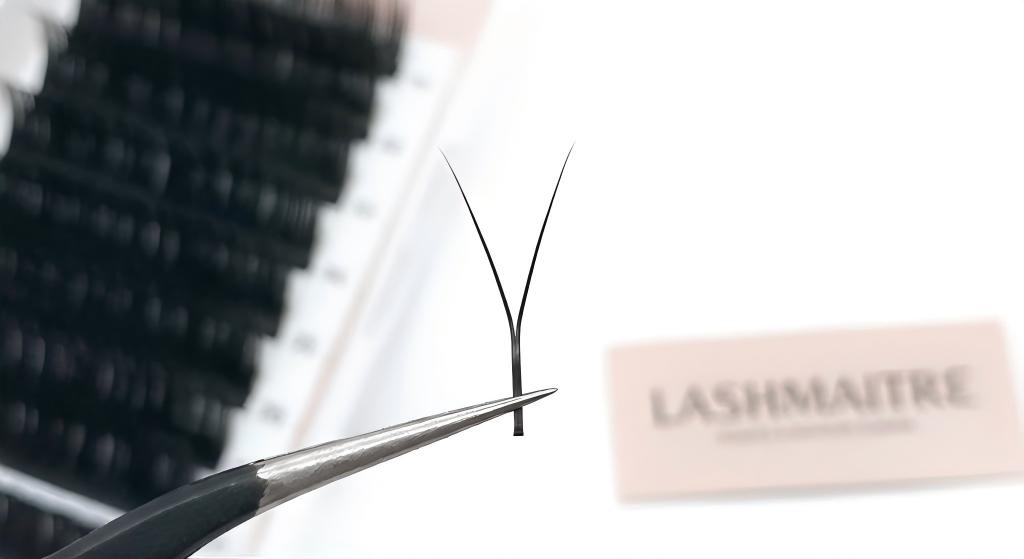 Macro photography of LASHMAITRE Y lash extensions showing the unique double-tip geometry and interlocking weave pattern used for instant 2D volume application.