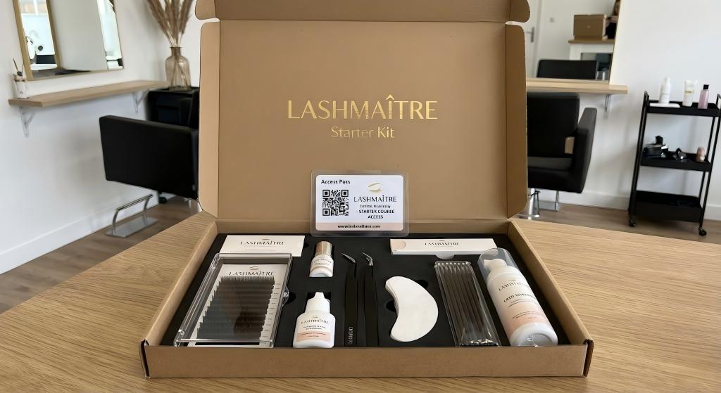 Open LASHMAITRE branded starter box displaying premium wholesale lash supplies with free training kit bundle, featuring eyelash extension trays, precision tweezers, adhesives, cleansers, and a QR code access pass to the online learning portal.