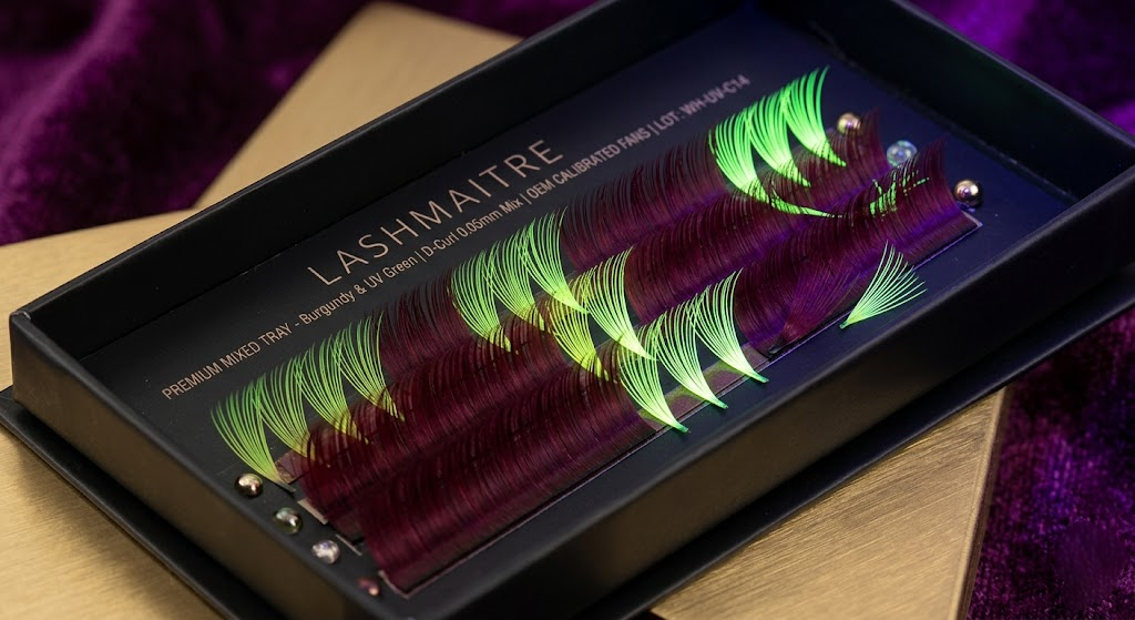 High-fashion macro photography showcasing a B2B premium mixed-color tray of colored eyelash extensions, featuring deep Burgundy and UV-Neon Green volume fans illuminated under dual standard light and 395nm blacklight.